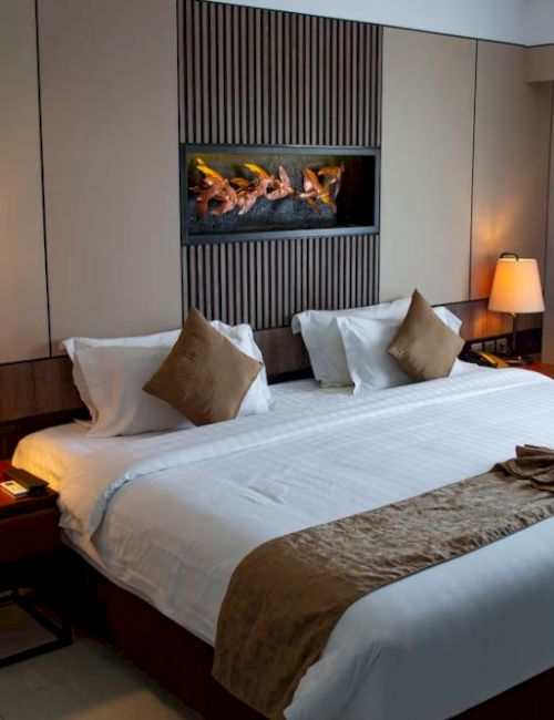 A cozy hotel room featuring a large, neatly made bed with brown accents, flanked by two bedside lamps, and a window with curtains.