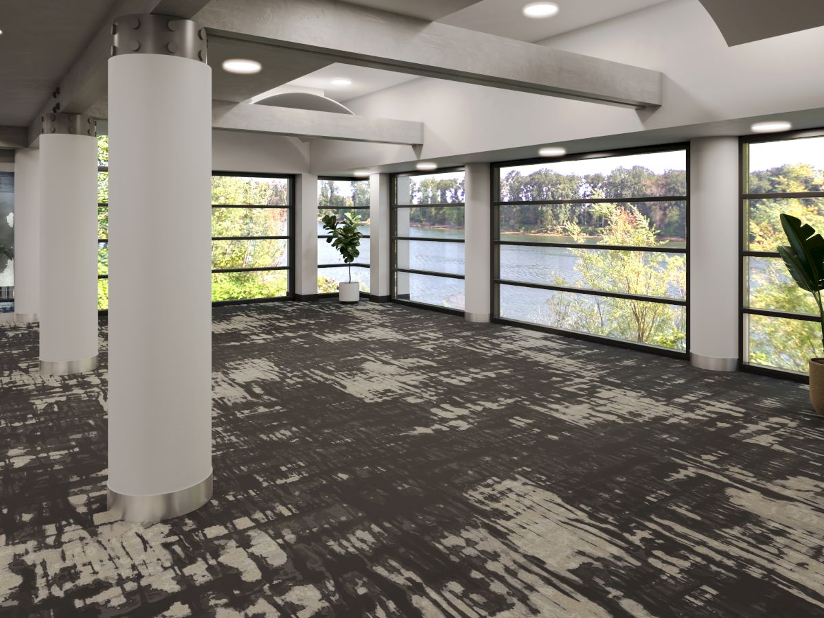 An empty room with large windows, modern carpet, and white columns, overlooking a scenic view with trees and water outside.