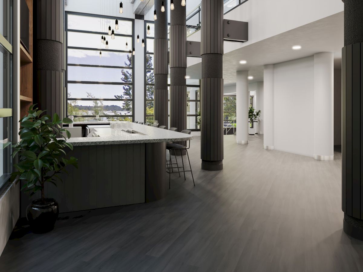 A modern, open interior with large windows, a sleek kitchen island, stools, and tall columns, offering a spacious and stylish environment.