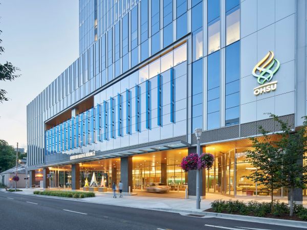 A modern glass-front office building with blue-tinted panels, bright ground-floor entrance, and a logo reading &ldquo;ONSU&rdquo; on the facade.